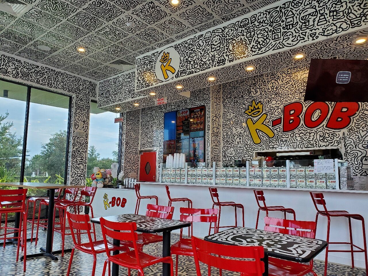 K-BOB's hand-painted comic-doodle dining room with red chairs and the signature K-BOB mural